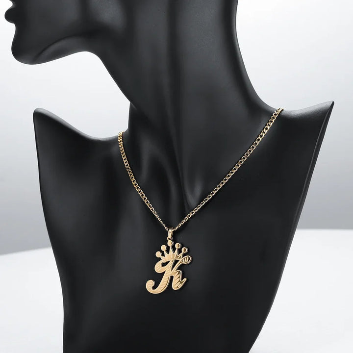 Gold Cursive Initial Crown Necklace for women displayed on a black mannequin