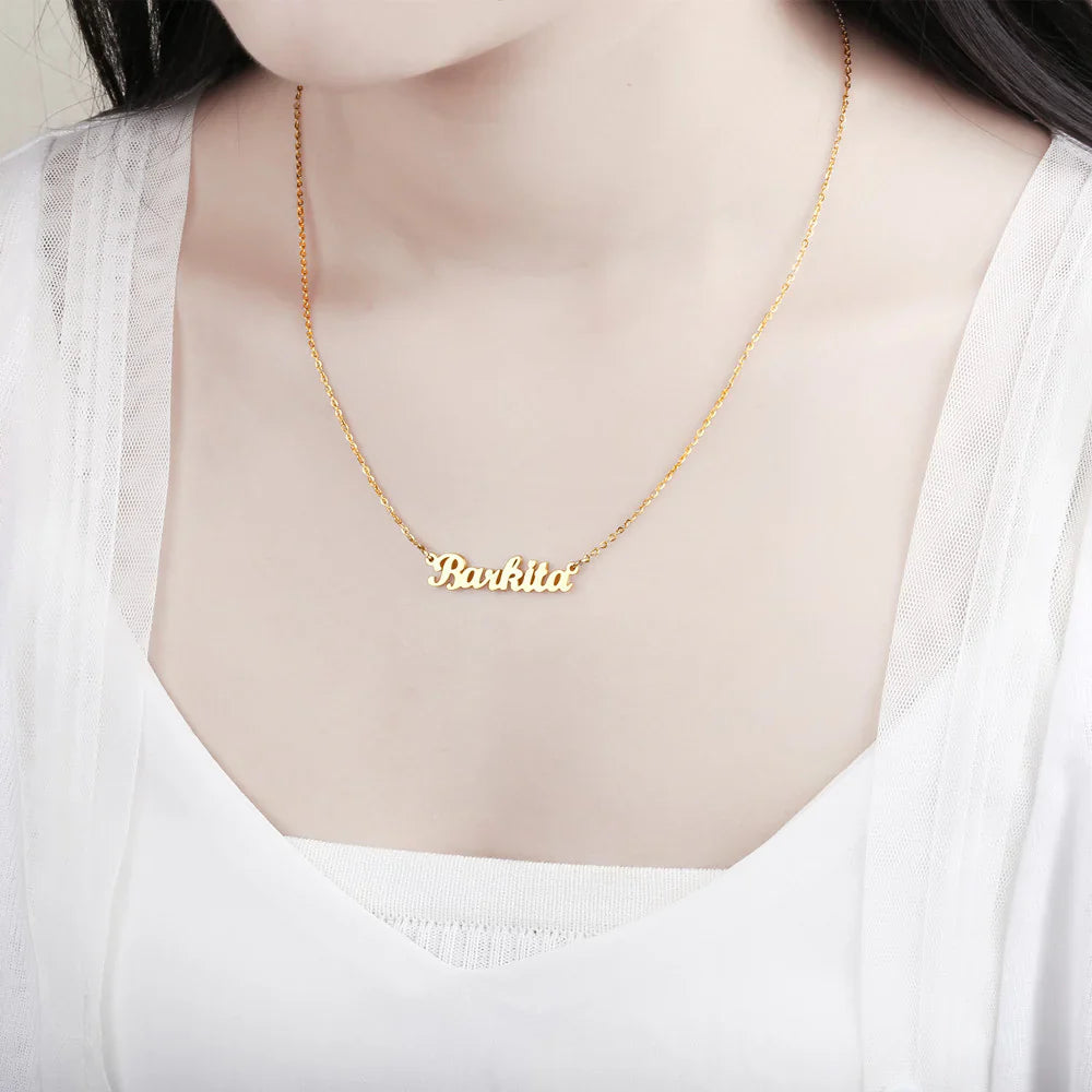 Model wearing gold custom name necklace with "Barkita" inscription.