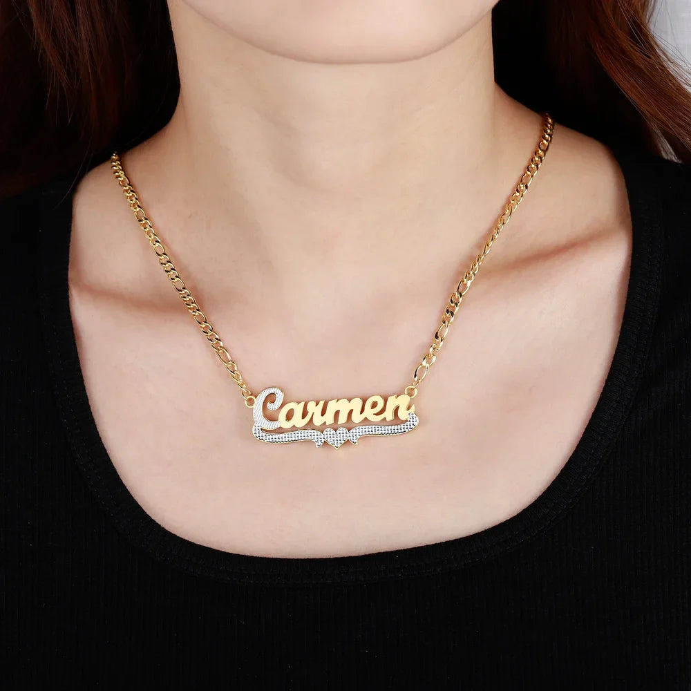 Model wearing Double Plated Cursive Name Necklace in Gold with heart design element and Figaro chain.