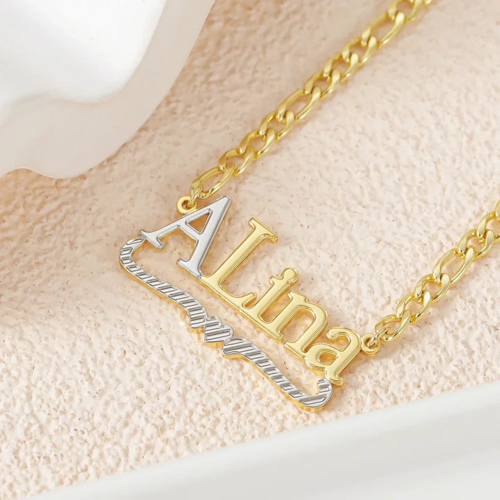 Closeup of Double Plated Initial Name Necklace in Gold on a textured background