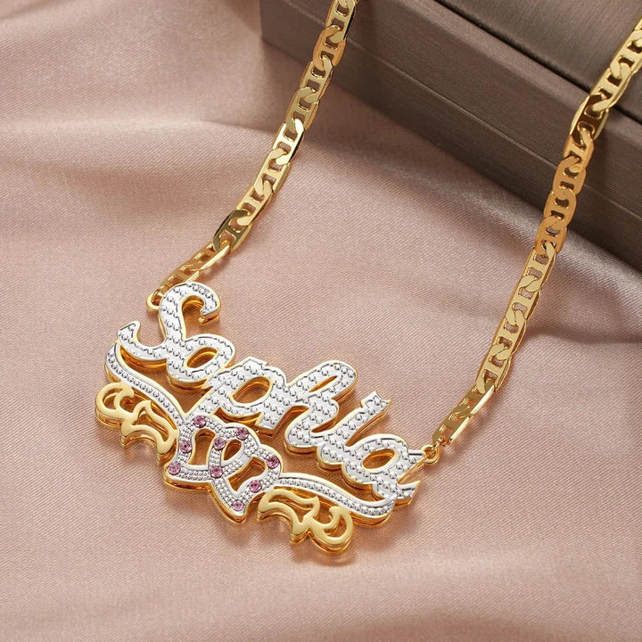 Flat lay of gold double plated intertwined hearts name necklace.