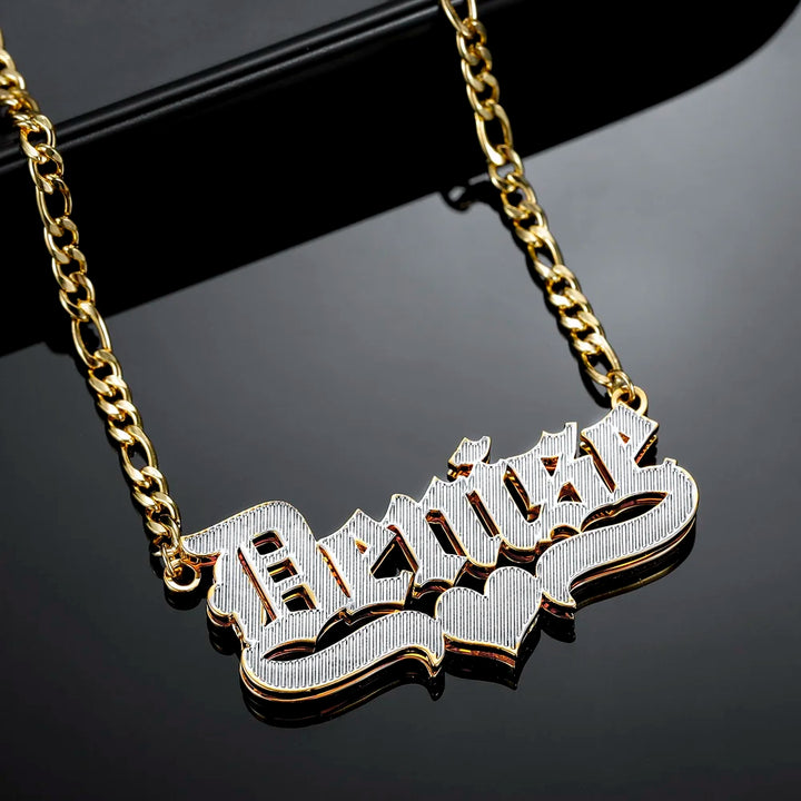 Angled view of Double Plated Old English Name Necklace in Gold with Figaro Chain