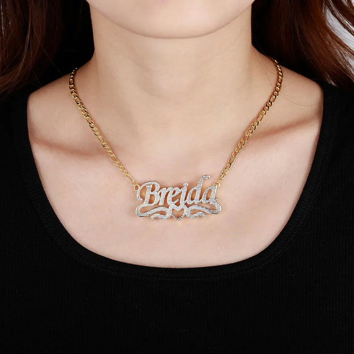 Double Plated Script Name Necklace in gold with Figaro chain worn by a model.