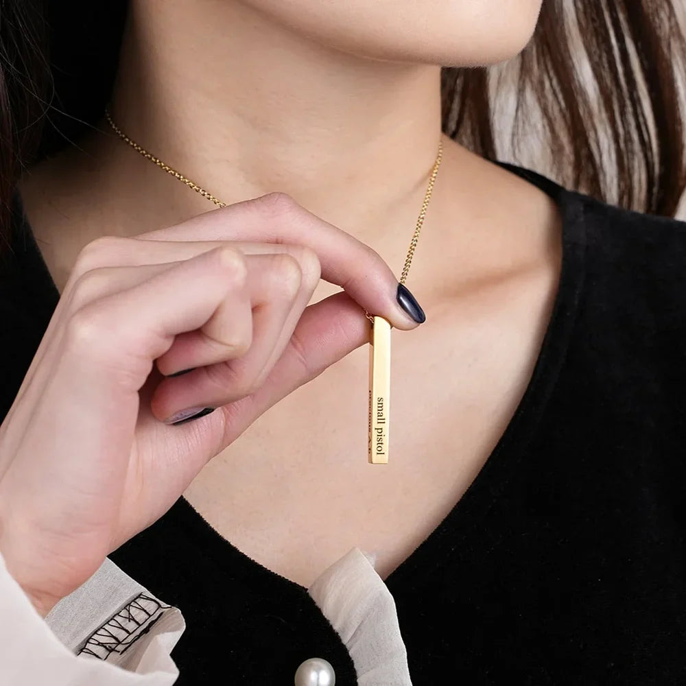 Close-up of a Gold Engraved Bar Name Necklace worn by a woman