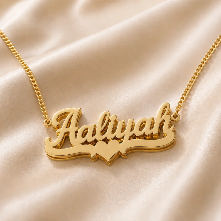 Gold personalized heart name necklace with Aaliyah name displayed on satin