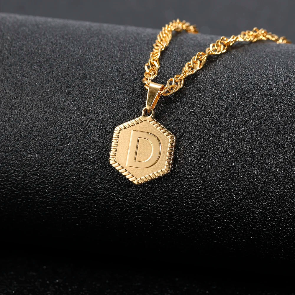 Hexagon Initial Necklace in 18k Gold displayed on black background