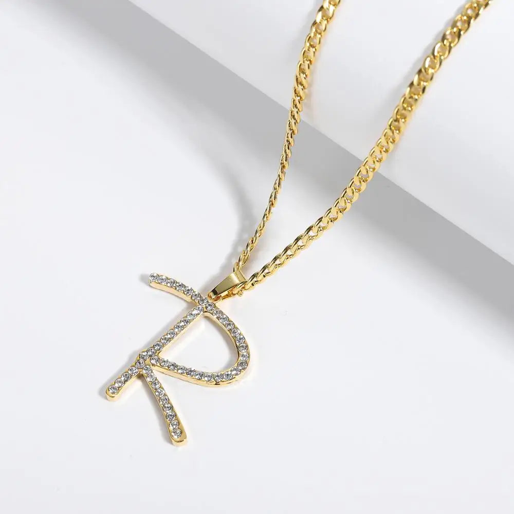 Display of Iced Cursive Initial Necklace in Gold on white background