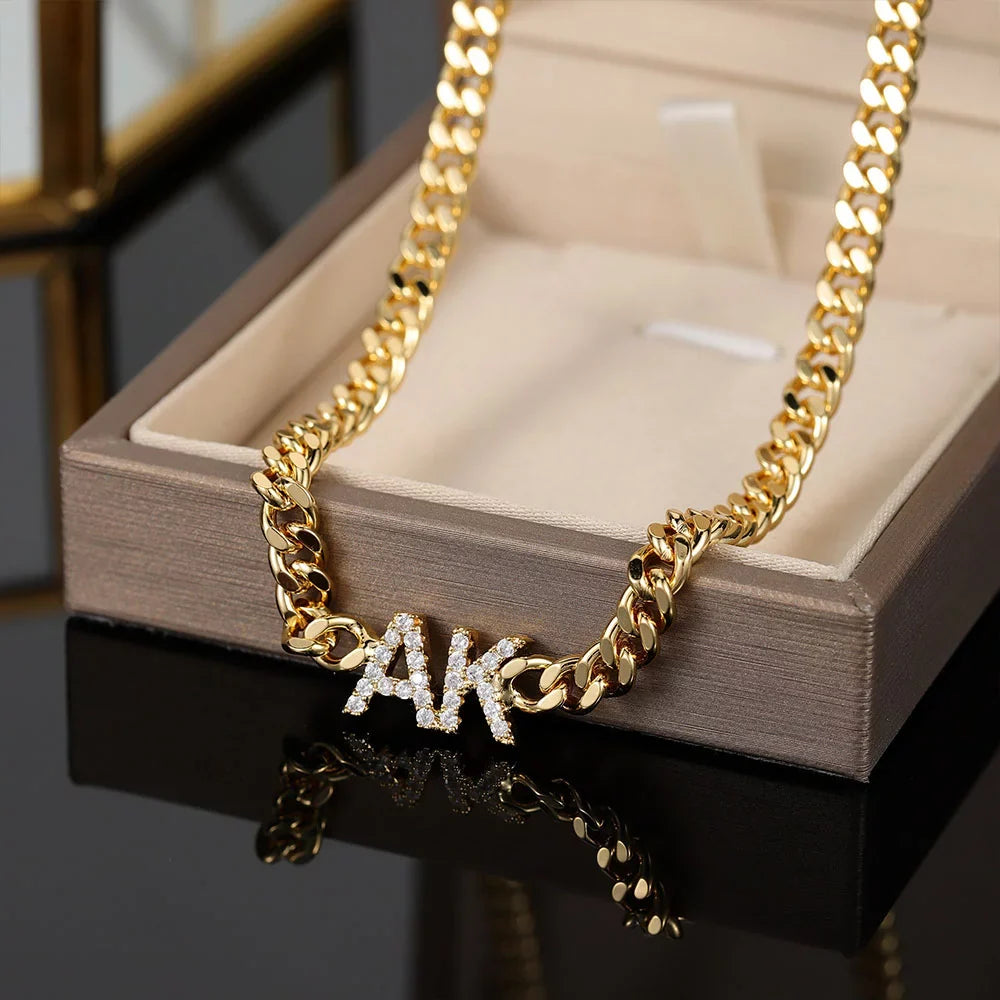 Iced initials necklace with cuban chain in gold, displayed in box