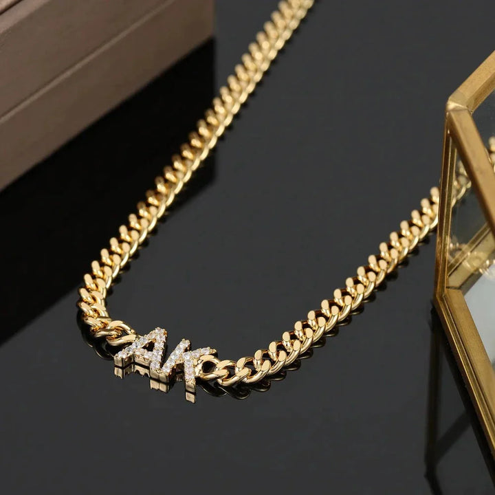 Full view of iced initials necklace with cuban chain in gold