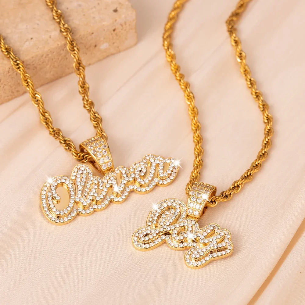 Two Iced Out Cursive Name Necklaces in gold displayed together