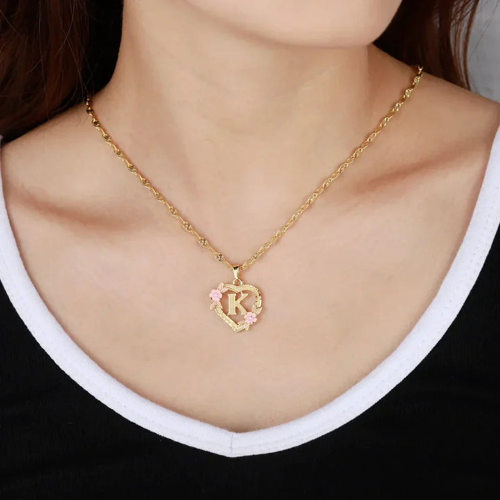 Model wearing gold Personalized Floral Initial Necklace with pink flowers and initial 'K'.