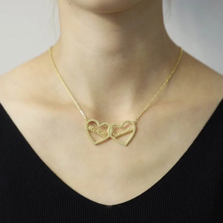 Model wearing gold twin hearts name necklace