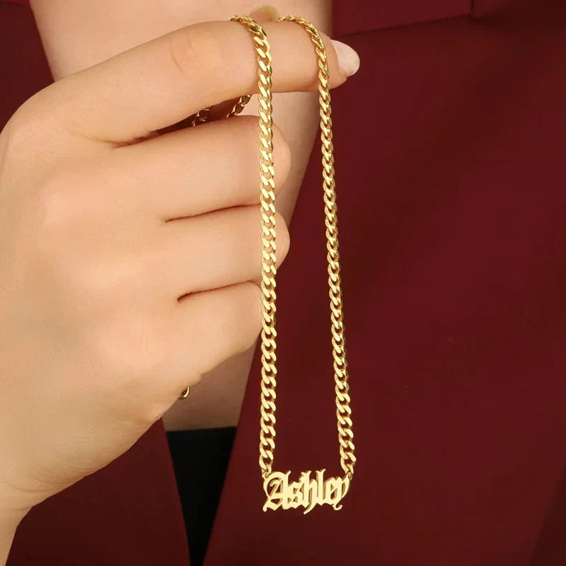 Old English name necklace with Cuban chain in gold, held by model