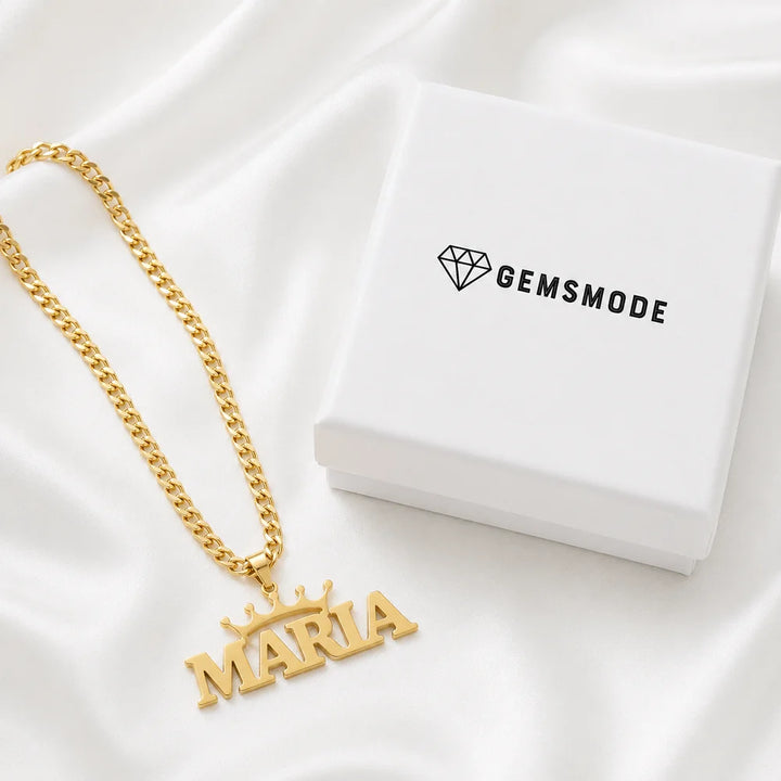 Personalized crown name necklace in gold with custom name "Maria" displayed on satin fabric beside a gemsmode gift box