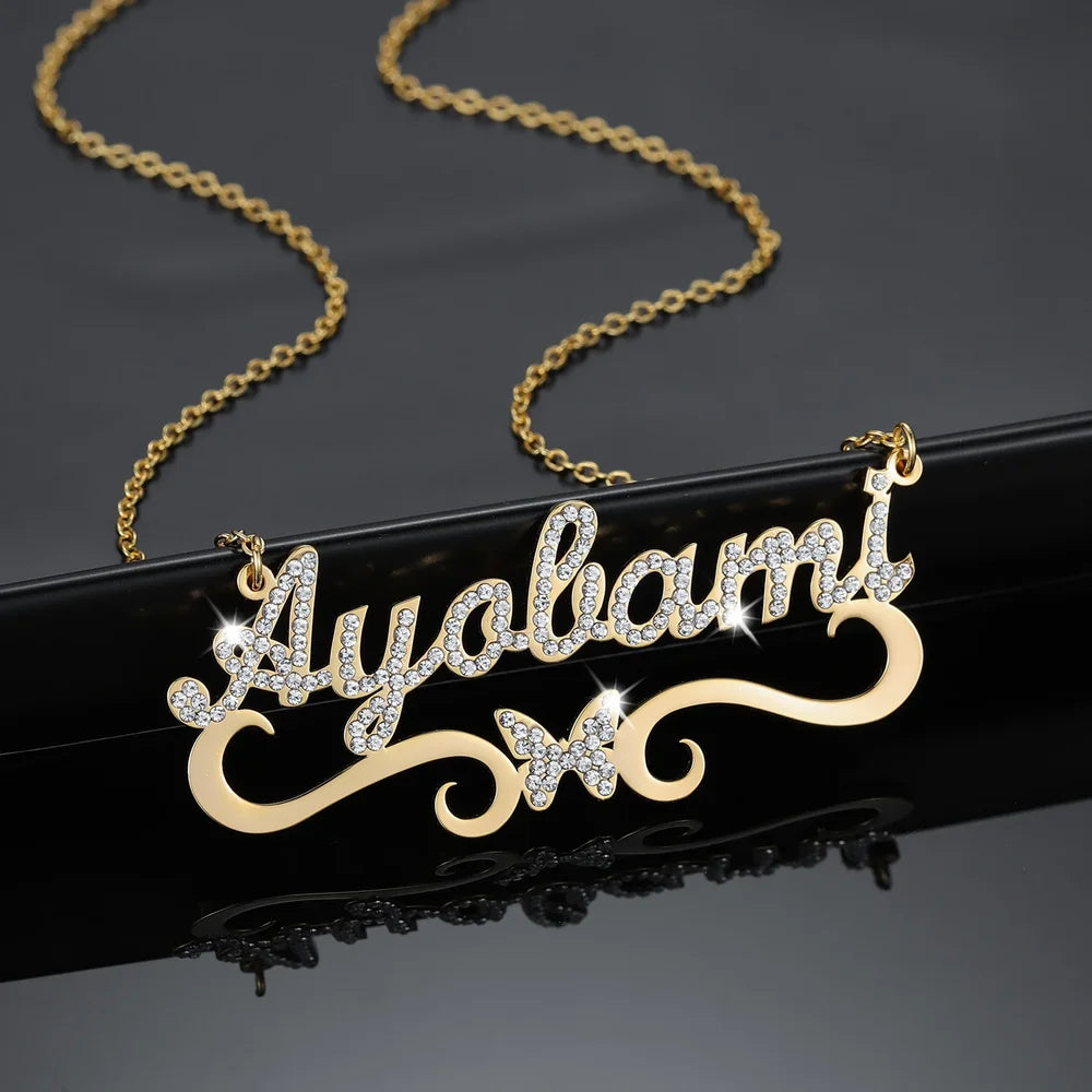 Close-up of personalized iced butterfly name necklace in gold