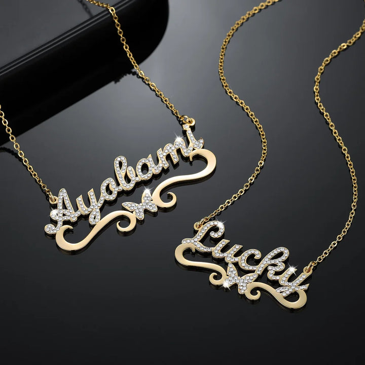  Display of two gold personalized iced butterfly name necklaces