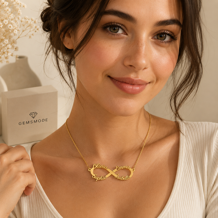 Smiling woman wearing gold personalized infinity name necklace with custom names Olivia, Emma, Sophia, and Isabella