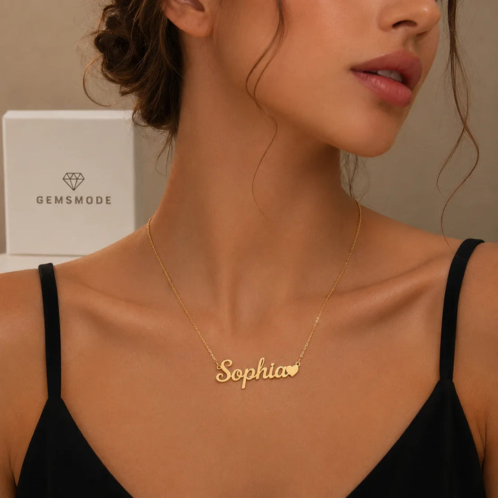 Woman wearing gold personalized name necklace with heart charm and custom name "Sophia"