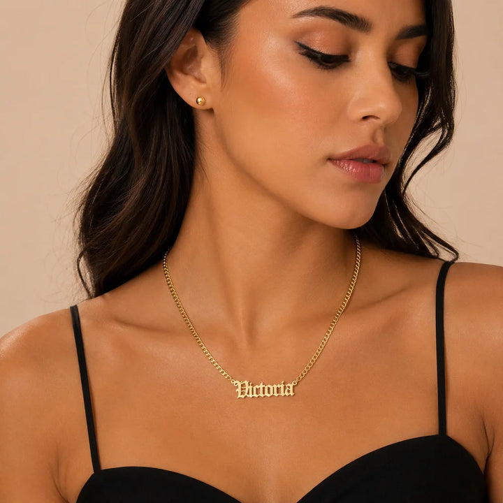 Woman wearing gold personalized old english name necklace with custom name "Victoria" on a Cuban chain